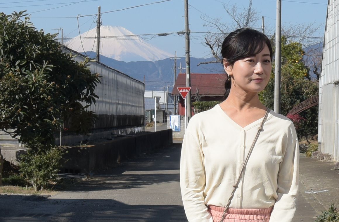 いちご街道の前に立つ女性